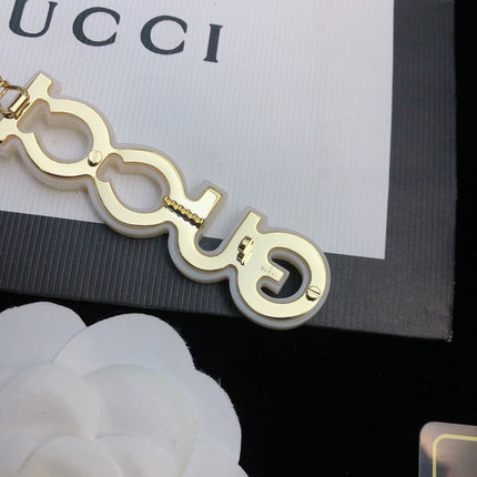 GUCCI 26S CRYSTAL EMBELLISHED SCRIPT LOGO STATEMENT BROOCH IN GOLD TONE METAL 629881