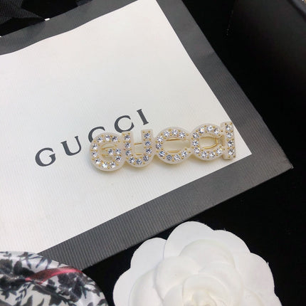 GUCCI 26S CRYSTAL EMBELLISHED SCRIPT LOGO STATEMENT BROOCH IN GOLD TONE METAL 629881