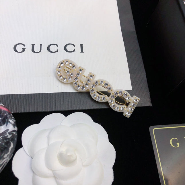 GUCCI 26S CRYSTAL EMBELLISHED SCRIPT LOGO STATEMENT BROOCH IN GOLD TONE METAL 629881