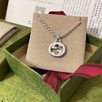 GUCCI 26S INTERLOCKING G LOGO CRYSTAL DISC PENDANT NECKLACE IN SILVER TONE METAL