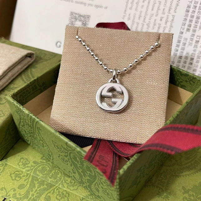 GUCCI 26S INTERLOCKING G LOGO CRYSTAL DISC PENDANT NECKLACE IN SILVER TONE METAL