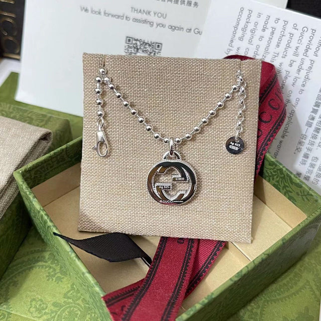 GUCCI 26S INTERLOCKING G LOGO CRYSTAL DISC PENDANT NECKLACE IN SILVER TONE METAL