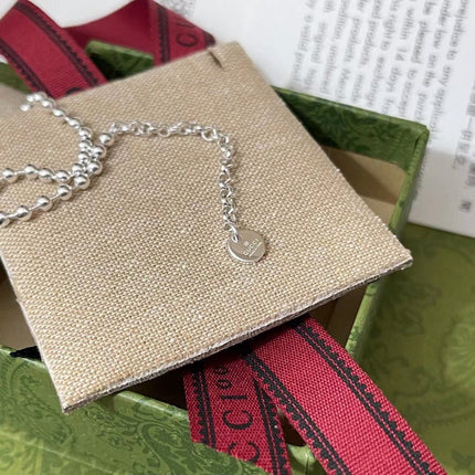 GUCCI 26S INTERLOCKING G LOGO CRYSTAL DISC PENDANT NECKLACE IN SILVER TONE METAL