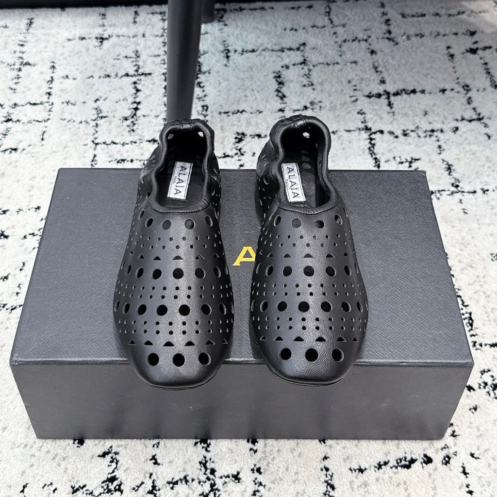 ALAIA 26S FLAT SLIP-ONS IN BLACK CALFSKIN WITH OPENWORK PATTERN