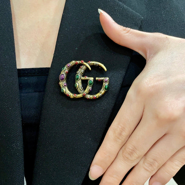 GUCCI 26S INTERLOCKING G MULTICOLOR GEM LOGO BROOCH IN ANTIQUE GOLD TONE METAL 625634