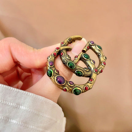 GUCCI 26S INTERLOCKING G MULTICOLOR GEM LOGO BROOCH IN ANTIQUE GOLD TONE METAL 625634