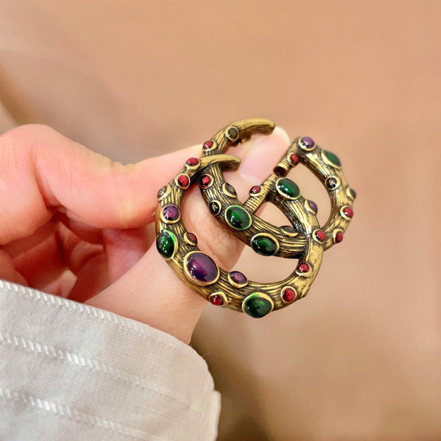GUCCI 26S INTERLOCKING G MULTICOLOR GEM LOGO BROOCH IN ANTIQUE GOLD TONE METAL 625634