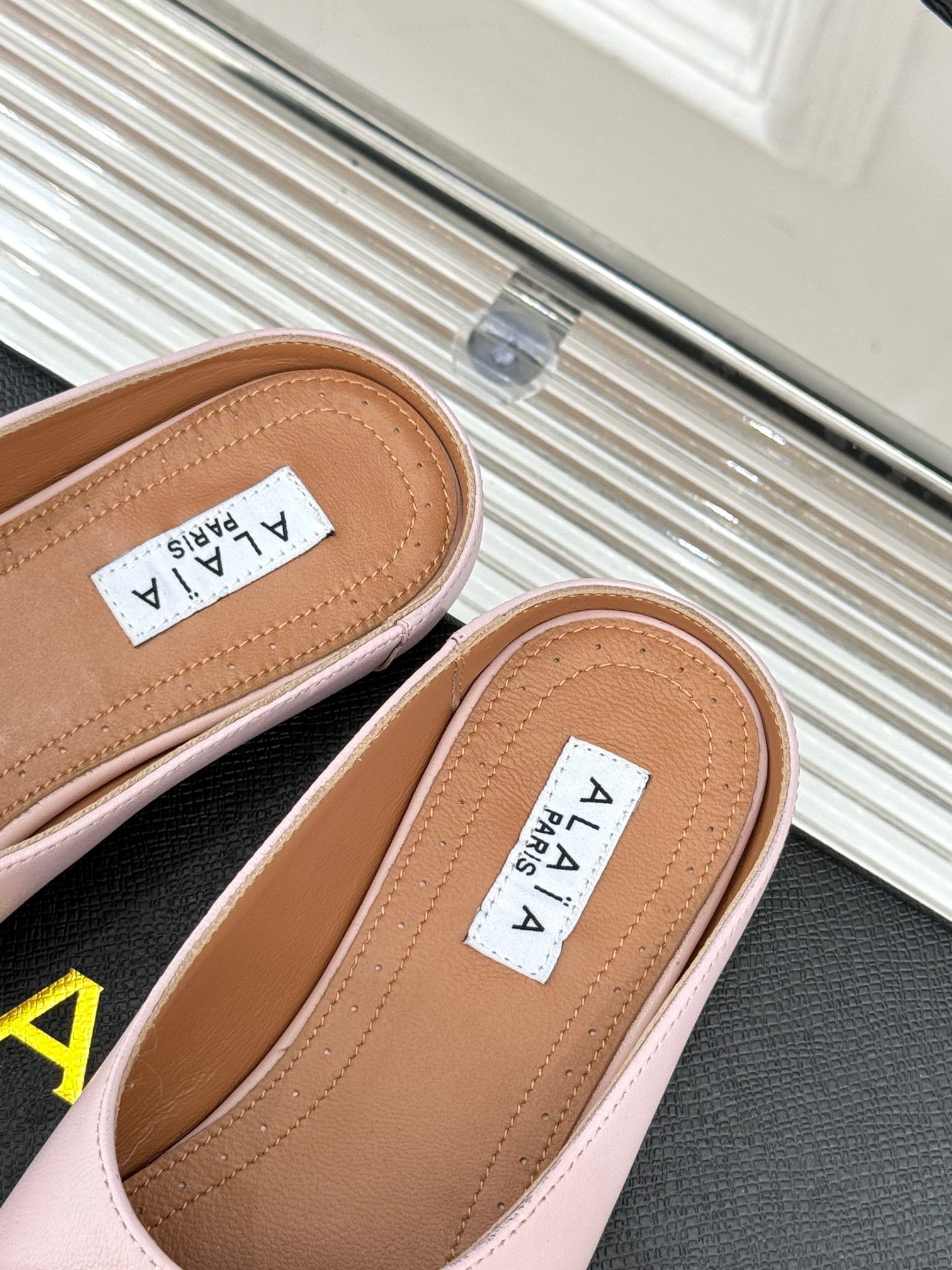 ALAIA FLAT MULE IN LIGHT PINK LAMBSKIN WITH GOLD HARDWARE