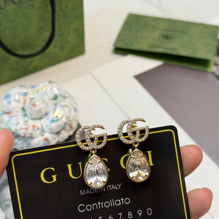 GUCCI 26S INTERLOCKING GG CRYSTAL TEARDROP EARRINGS IN GOLD TONE METAL 621443