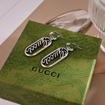 GUCCI 26S SCRIPT LOGO OVAL DROP EARRINGS IN SILVER TONE METAL 633780